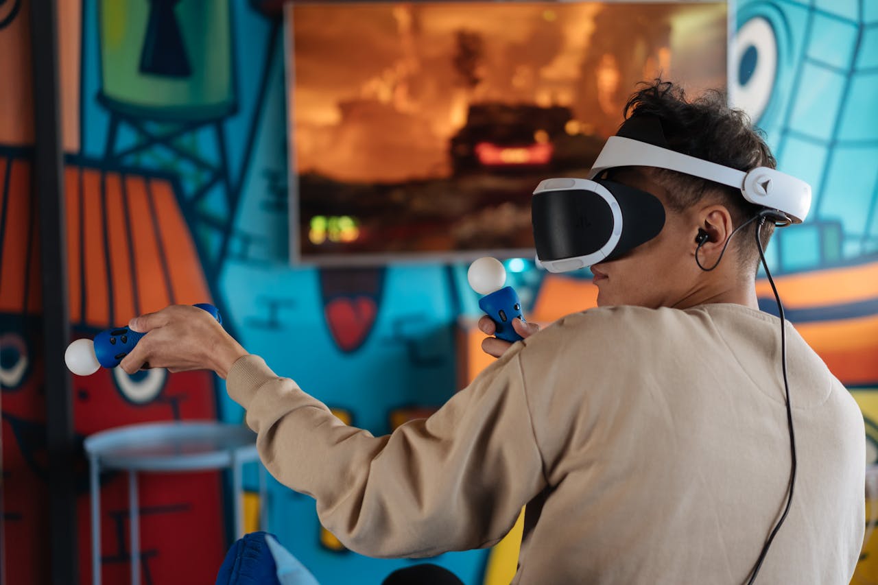 Person enjoying virtual reality gaming with VR headset and controllers in a vibrant room.
